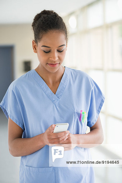 Krankenschwester Textnachrichten mit einem Mobiltelefon
