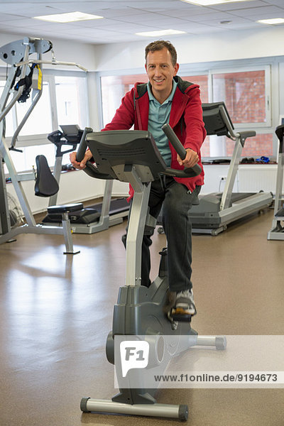 Man exercising on exercise bike in a gym
