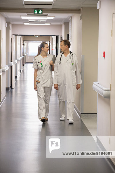 Doctor and female nurse walking in the corridor of a hospital