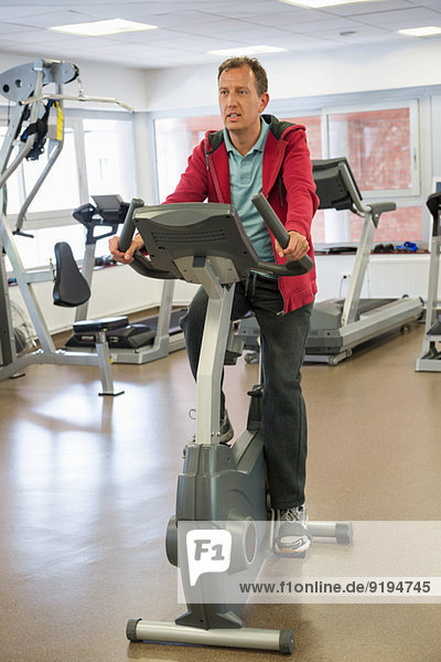 Man exercising on exercise bike in a gym