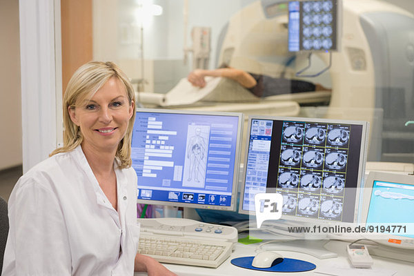 Female doctor smiling in medical MRI scan monitor room