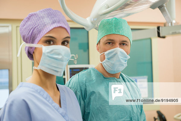 Female nurse and male surgeon in an operating room