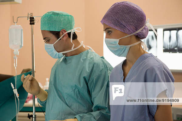 Male surgeon and female nurse in an operating room