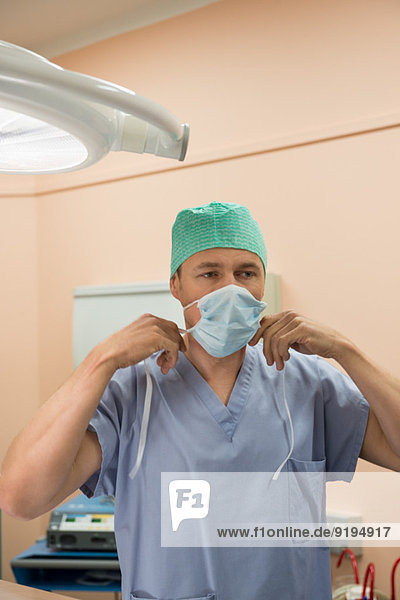 Male surgeon wearing surgical mask in an operating room