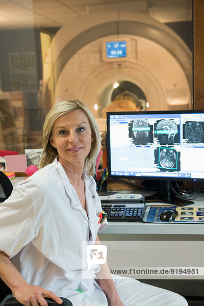 Ärztin untersucht Gehirn-MRT-Scan am Computer