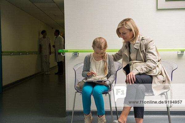 Woman with her daughter sitting in hospital waiting room