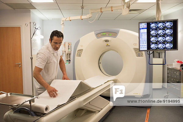 Male doctor preparing medical MRI scanner in hospital
