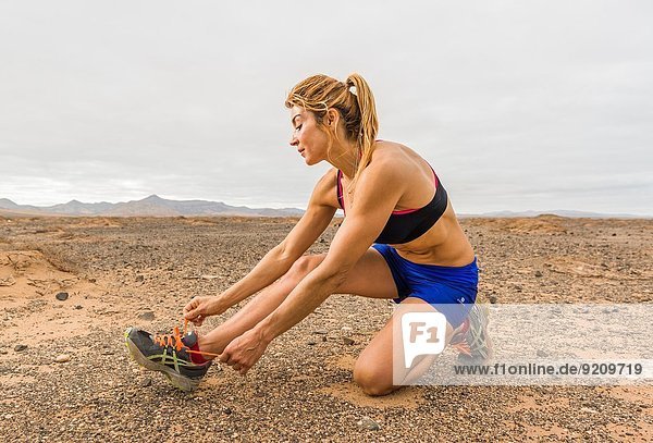 Woman tying her shoe laces. Fuerteventura  Canary Islands  Spain  Europe.