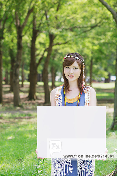 Japanese woman with white board in a park