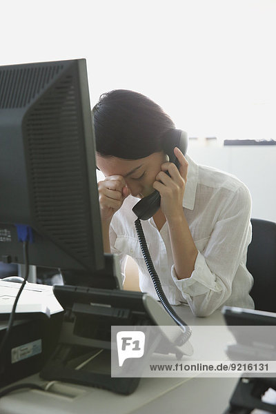 Japanese young businesswoman depressed at her office desk