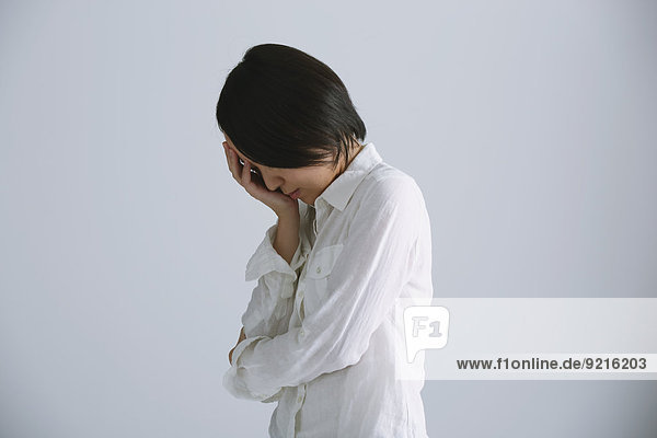 Desperate Japanese young woman in a white shirt
