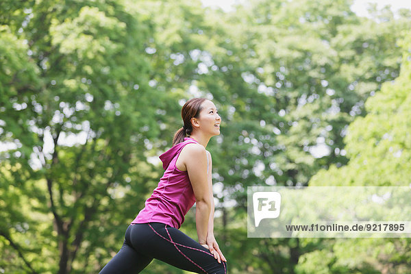 Young Japanese girl stretching in the park