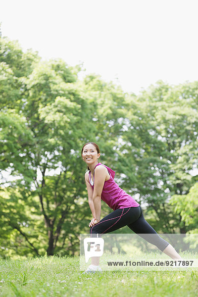 Young Japanese girl stretching in the park