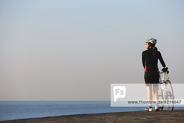 Young Japanese girl with racing bike at sunset