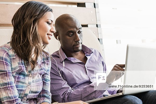 Männliche und weibliche Geschäftskollegen bei der Arbeit am Laptop im Büro