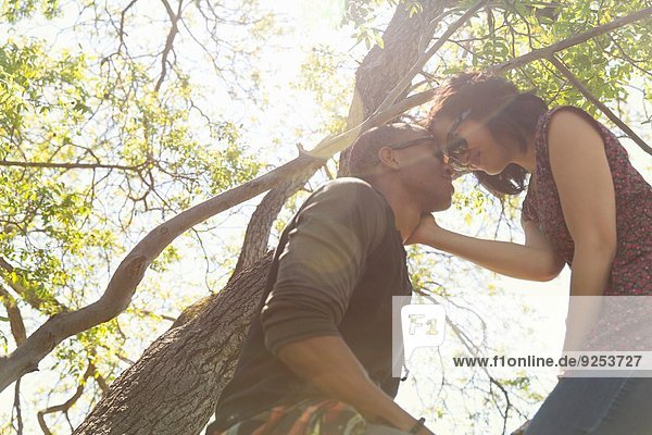 Romantisches junges Paar von Angesicht zu Angesicht im Baum