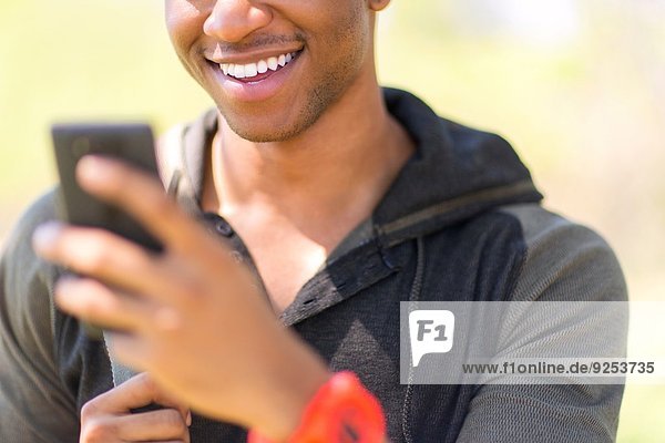 Close up of young male hiker looking at smartphone