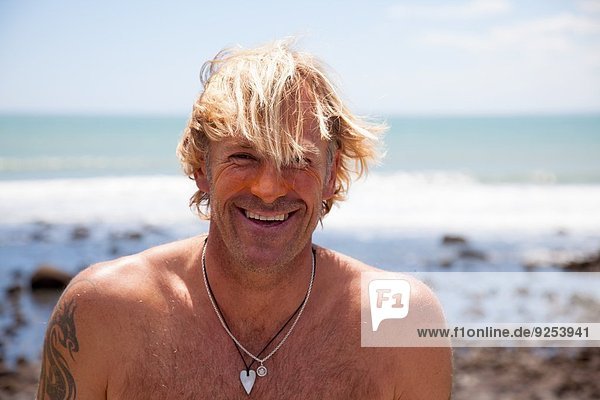 Porträt eines lächelnden reifen Mannes mit Sonnencreme im Gesicht
