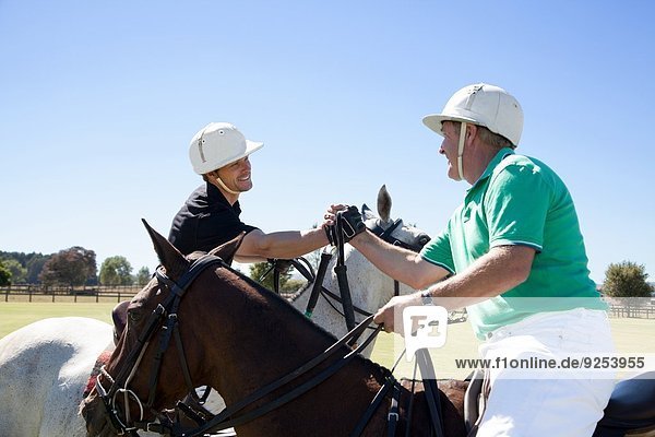 Two polo players shaking hands