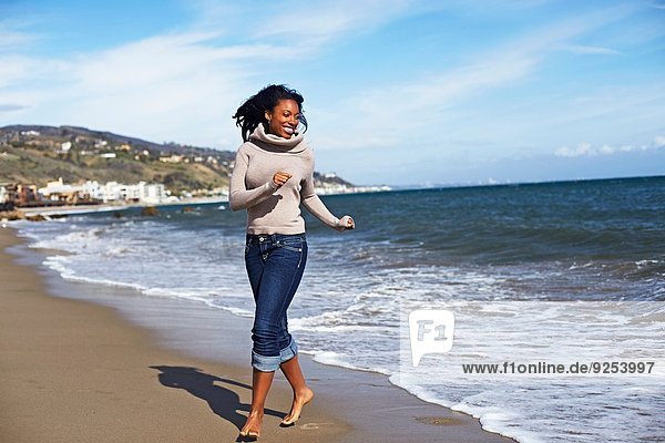 Young woman walking barefoot on beach  Malibu  California  USA