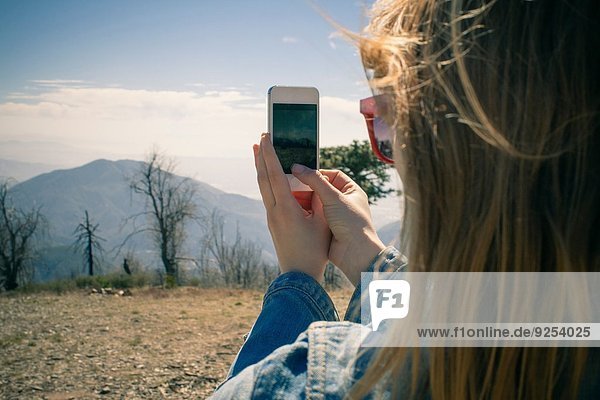 Ausschnittaufnahme einer mittleren erwachsenen Frau beim Fotografieren auf dem Smartphone  Lake Arrowhead  Kalifornien  USA