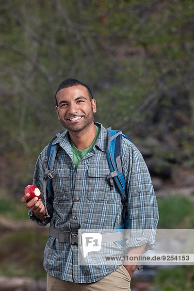 Portrait of young male hiker eating apple  Sedona  Arizona  USA
