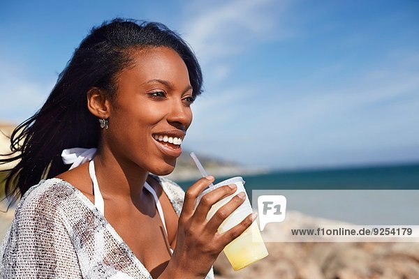 Junge Frau trinkt Fruchtsaft am Strand  Malibu  Kalifornien  USA