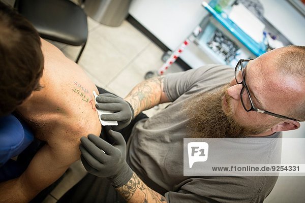 Tätowierer beendet ein frisches Tattoo