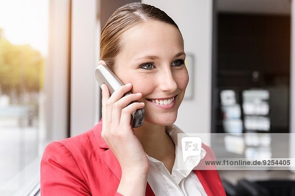 Porträt einer jungen Geschäftsfrau im Gespräch auf dem Handy