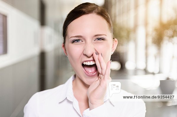 Portrait of young businesswoman shouting in office