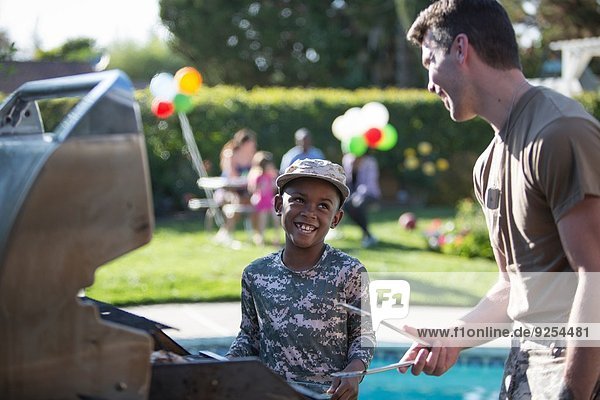 Männlicher Soldat und Junge beim Grillen auf der Homecoming-Party