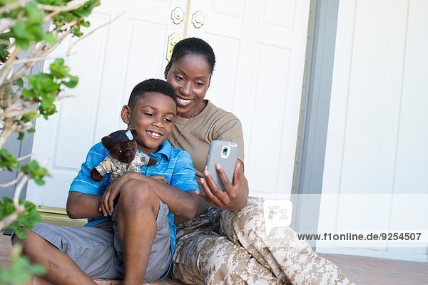 Soldatin nimmt Selfie mit Sohn vor der Haustür beim Homecoming mit.