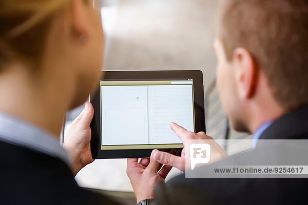 Über-Schulter-Ansicht von Geschäftsfrau und Mann mit digitalem Tablett im Büro
