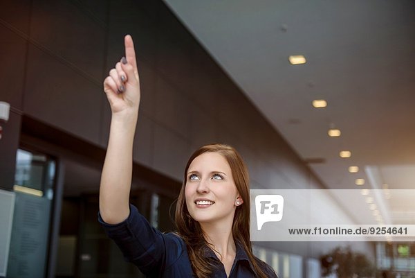 Young businesswoman gesturing with finger in office