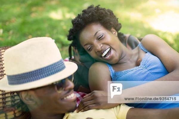 Junges Paar im Park liegend zusammen lachend
