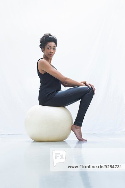 Young woman sitting on fitness ball