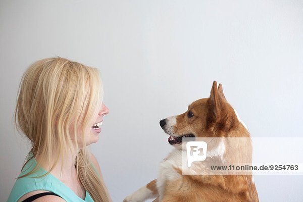 Porträt des süßen Corgi-Hundes von Angesicht zu Angesicht mit junger Frau