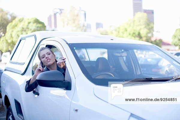 Young businesswoman shouting from car window in city