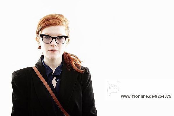 Atelierporträt einer jungen Frau mit Brille und leerem Gesichtsausdruck