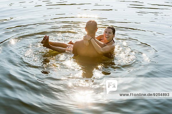 Junger Mann mit Freundin im Arm im Fluss