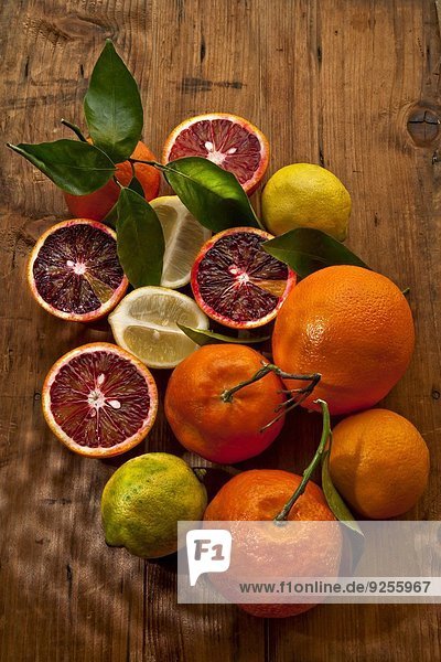 Blutorangen  Mandarinen und Zitronen auf Holzuntergrund (Draufsicht)