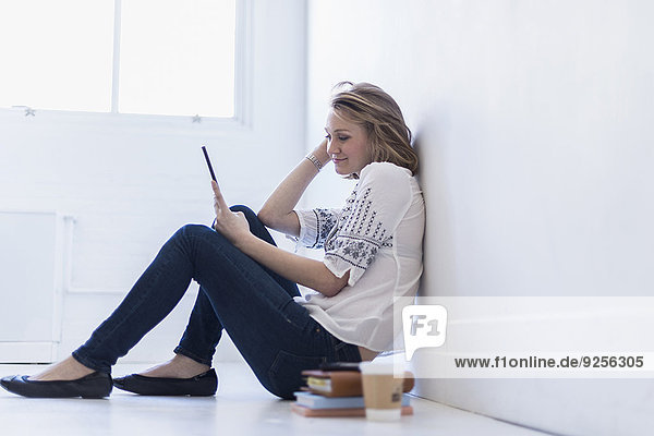 sitzend junge Frau junge Frauen benutzen Boden Fußboden Fußböden Tablet PC