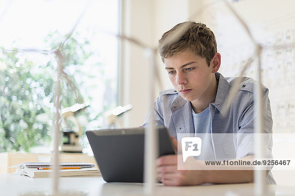Teenage boy (16-17) using digital tablet in laboratory
