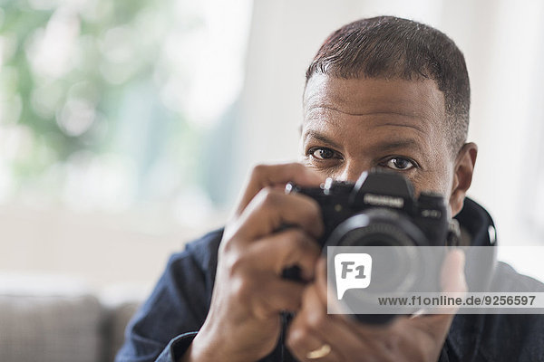 Portrait of man holding digital camera