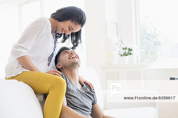 Happy young couple playing on sofa
