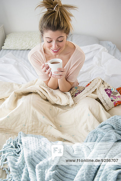 sitzend junge Frau junge Frauen Bett Kaffee