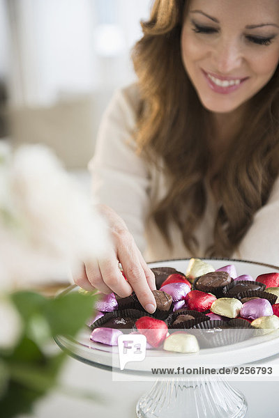 Woman choosing chocolate from cake stand