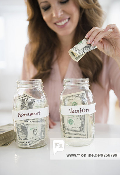 Woman putting money in jar