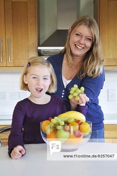 Mutter und Tochter mit Obstschale in der Küche