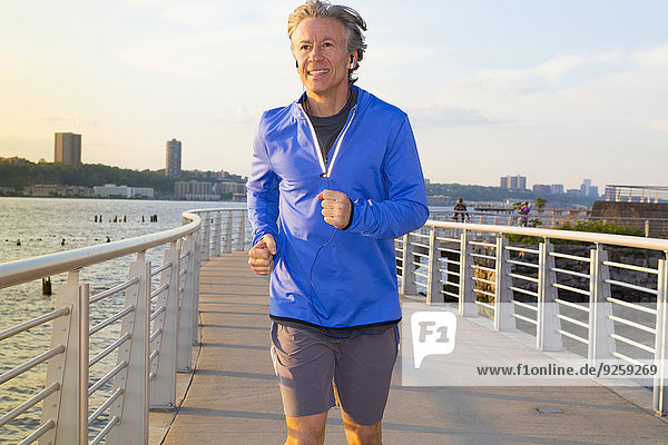 Caucasian man jogging on urban waterfront